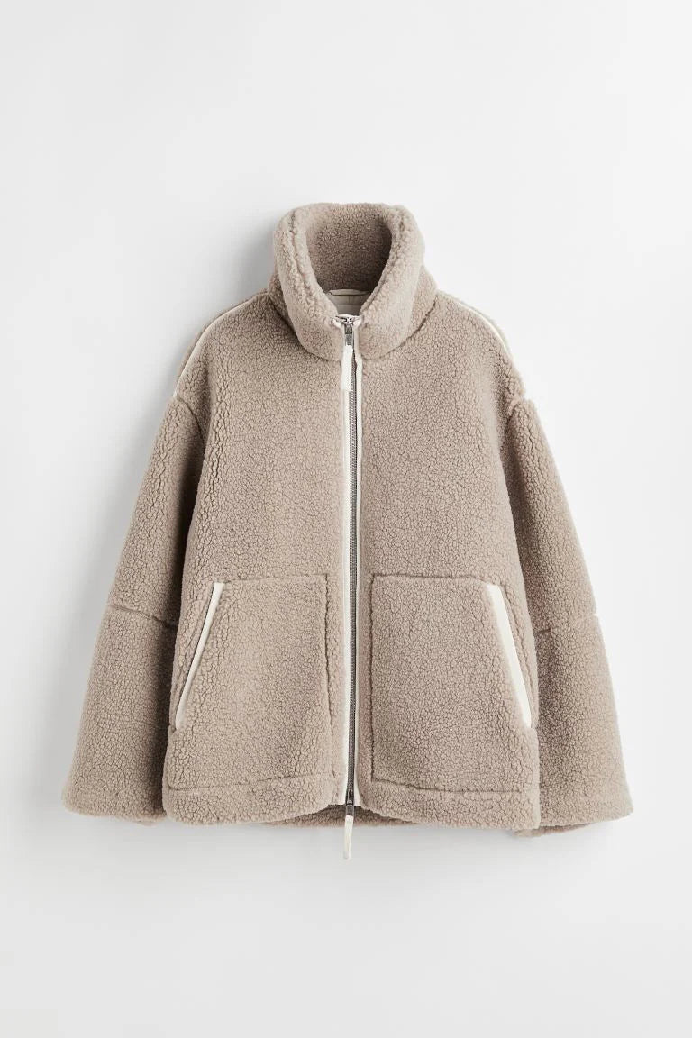 Modieuze beige teddy tussenjas voor dames, ruimvallend design met opstaande kraag, geschikt voor herfst en milde winter.