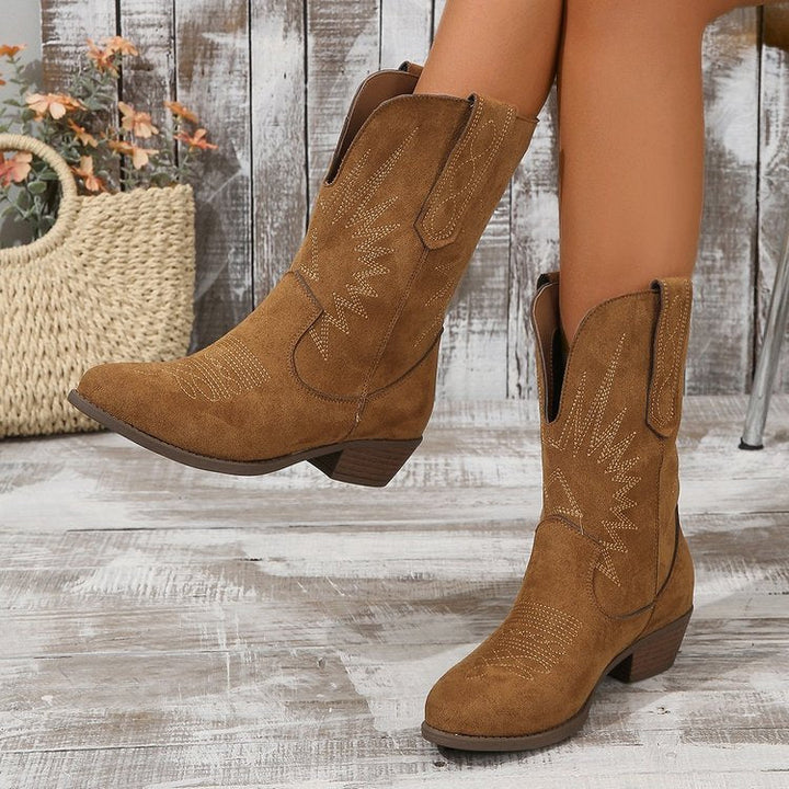Comfortabele bruine dames enkellaarzen in trendy cowboy stijl. Stijlvolle mode laarzen voor vrouwen.