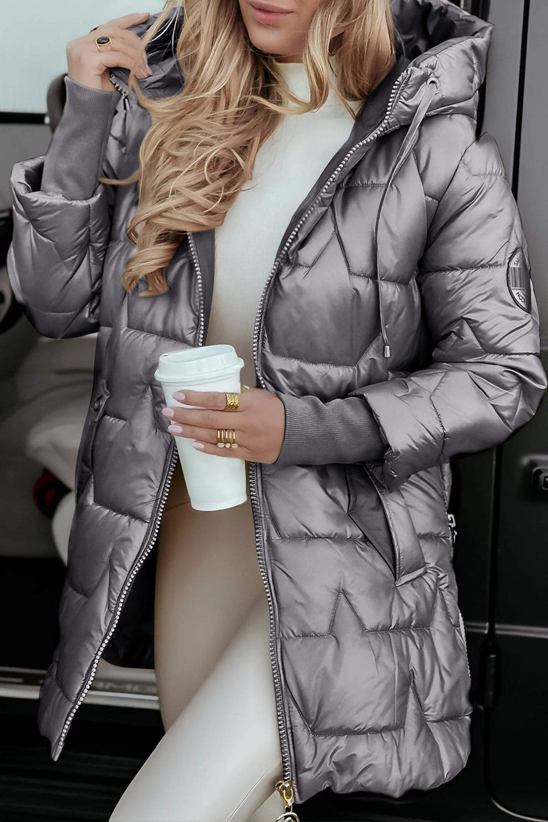 Damesmodel toont Cédrine capuchonjas. Warme en stijlvolle lange jas, perfect voor koude herfst- en winterdagen.