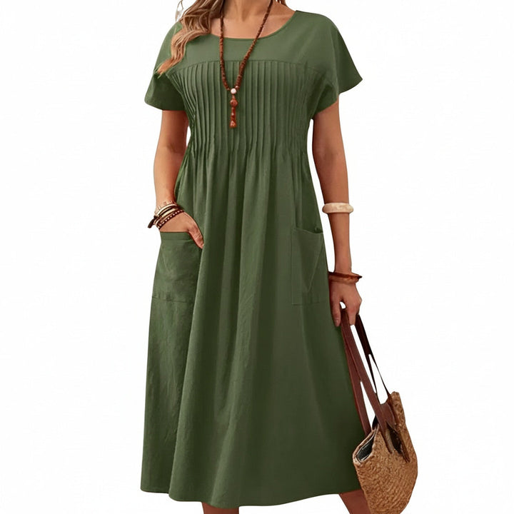 Casual blauwe midi damesjurk met korte mouwen, ronde hals en praktische zijzakken, perfect voor de zomer.