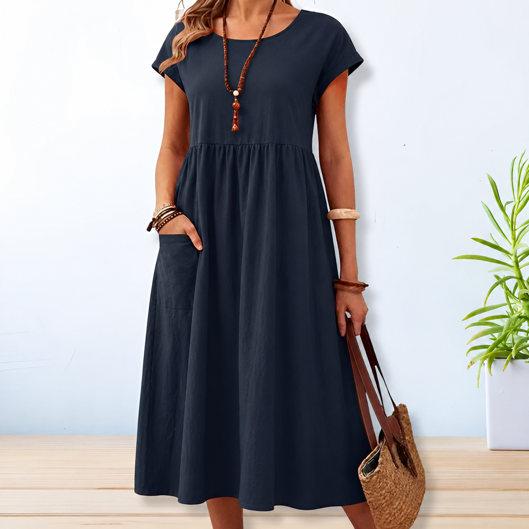 Stijlvolle midi damesjurk in blauw met korte mouwen, ronde hals en handige zijzakken voor een zomerse look.