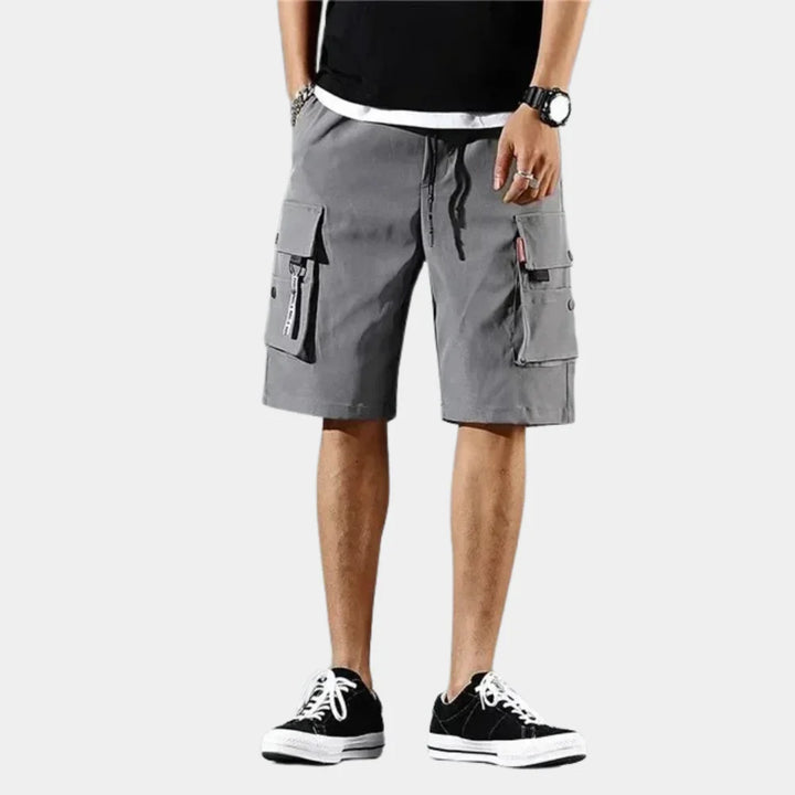 Model draagt comfortabele heren cargo shorts met loose fit en elastische tailleband, ideaal voor vrije tijd.