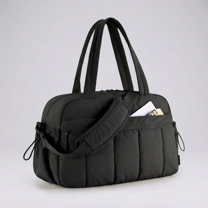 Aerelle compacte reisduffeltas op vliegveld, klaar als handbagage. Ideale lichtgewicht reistas voor korte trips en vakanties.