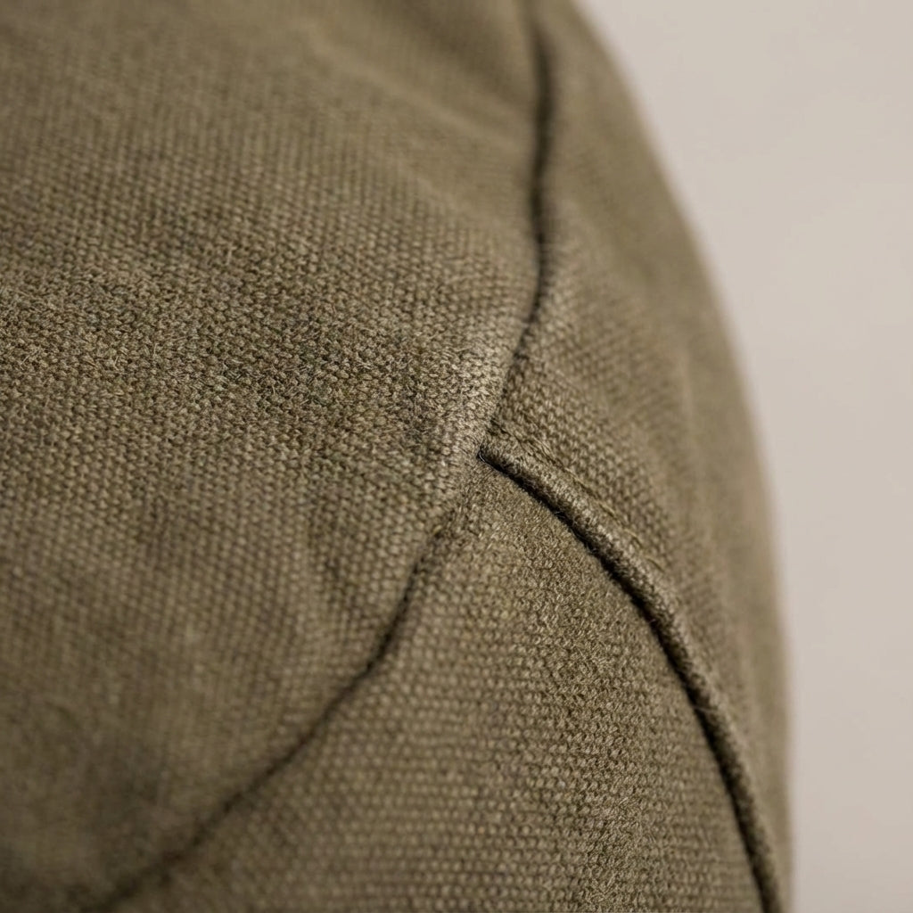 Unisex model draagt de compacte vintage canvas schoudertas als messenger bag, stijlvol en praktisch.