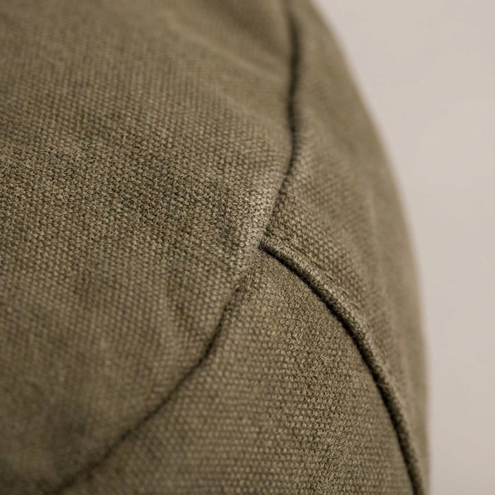 Unisex model draagt de compacte vintage canvas schoudertas als messenger bag, stijlvol en praktisch.