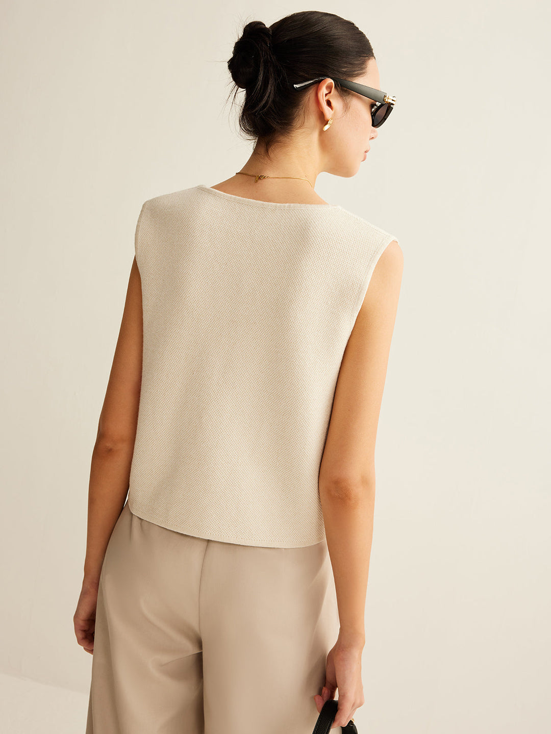 Textuur van gebreid dames asymmetrisch vest met knoopsluiting, zacht en comfortabel voor elke vrouw.