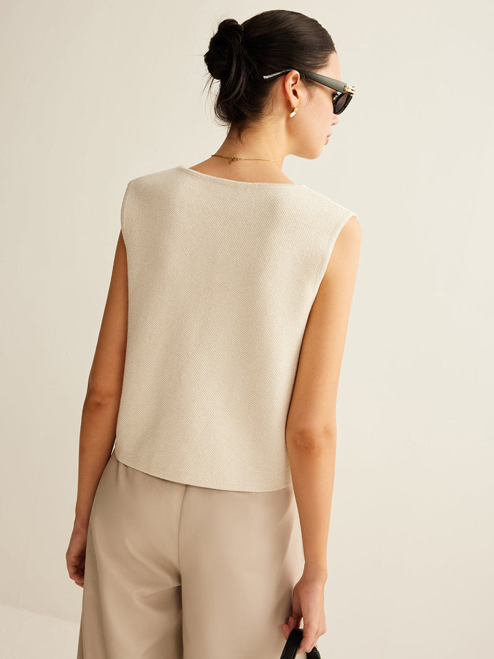 Textuur van gebreid dames asymmetrisch vest met knoopsluiting, zacht en comfortabel voor elke vrouw.