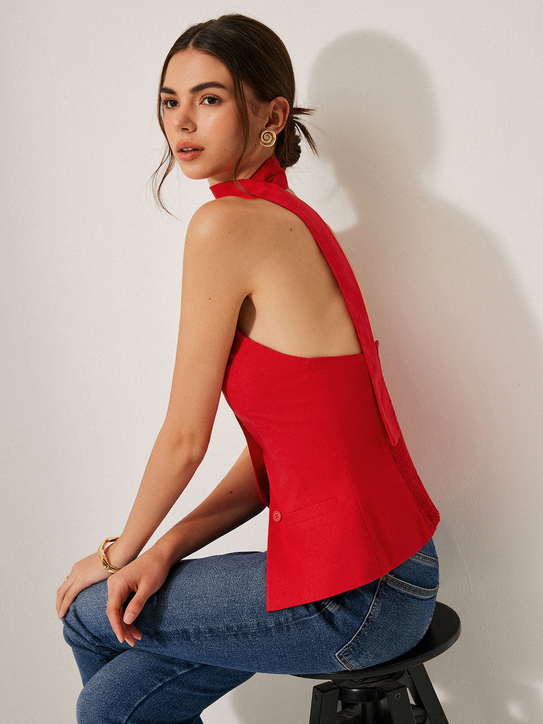 Trendy dames vesttop met openrug en asymmetrische halternek, een stijlvolle keuze voor zomeravonden.