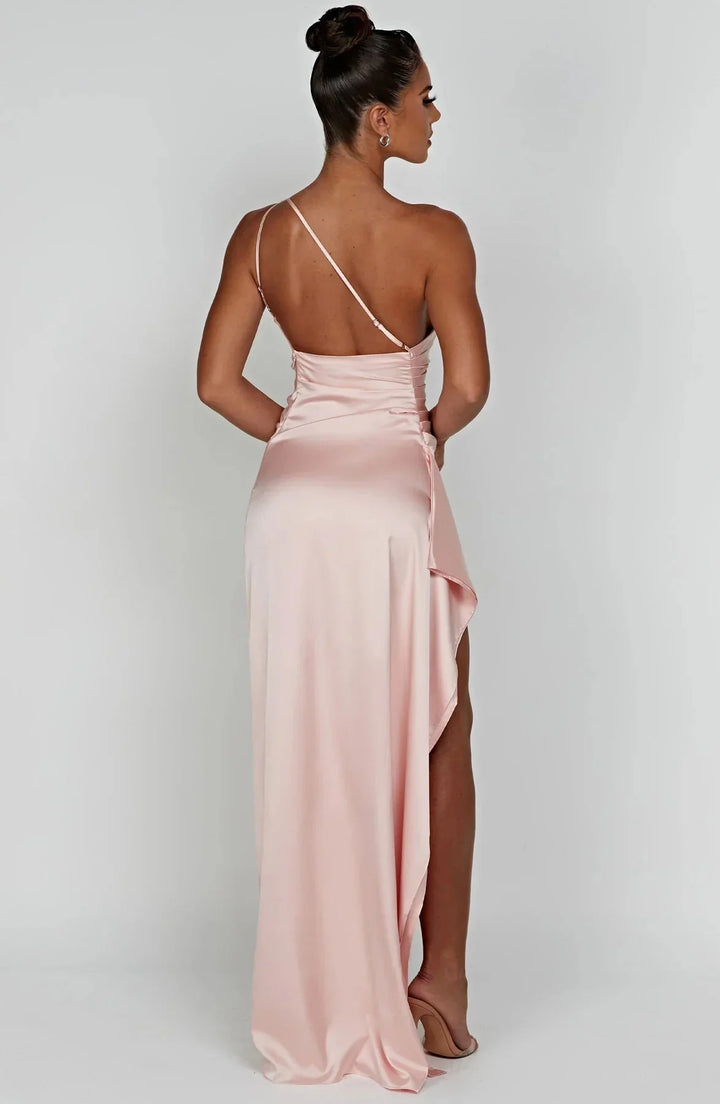 Maxi avondjurk met open rug, één schouder detail, vallende plooien en een hoge split voor elegantie.