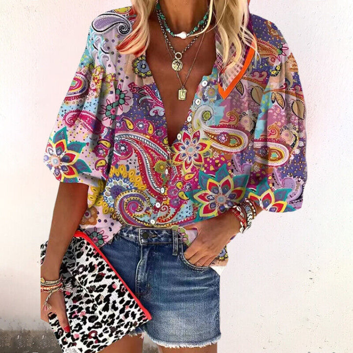 Luchtige dames top met bloemenprint, praktische knoopsluiting en elegante halve mouwen, perfect voor de zomer.