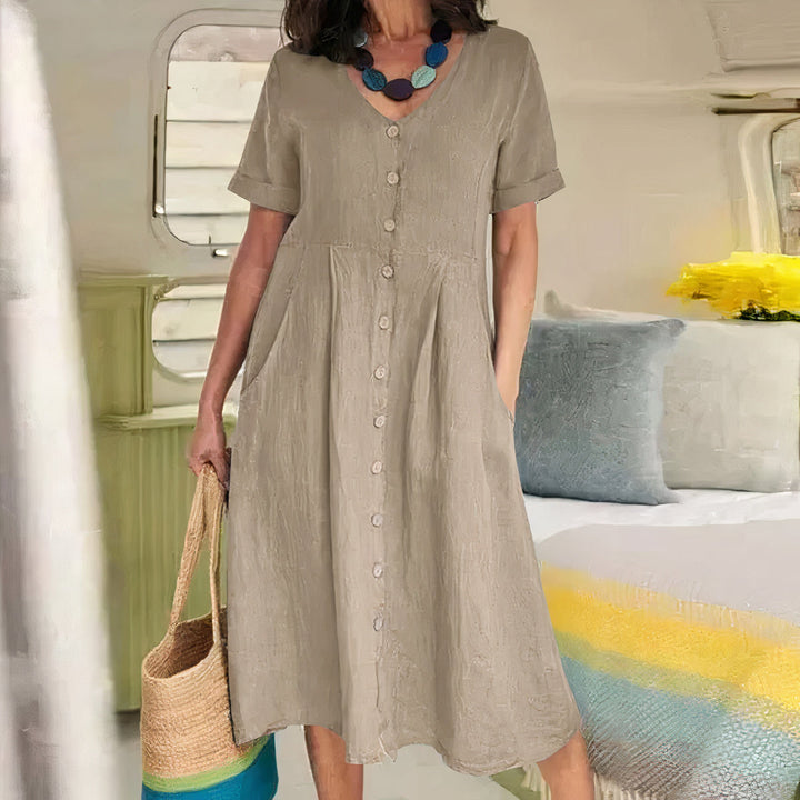 Luchtige dames zomerjurk met V-hals, knoopdetail en flatterende A-lijn silhouet.