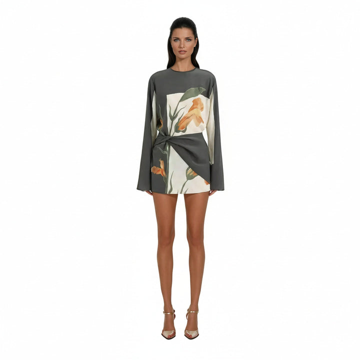 Dames cocktailjurk met lange mouw, elegante bloemenprint en unieke gedraaide taille detail.