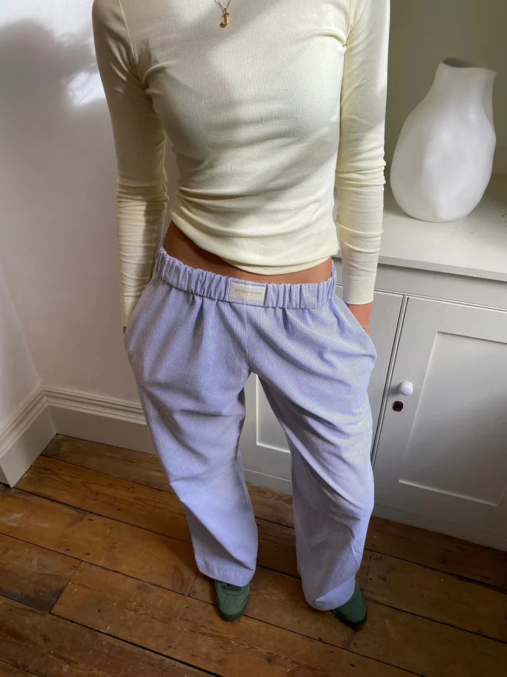 Model draagt een comfortabele dames loungebroek, toont relaxte elegantie en veelzijdigheid.