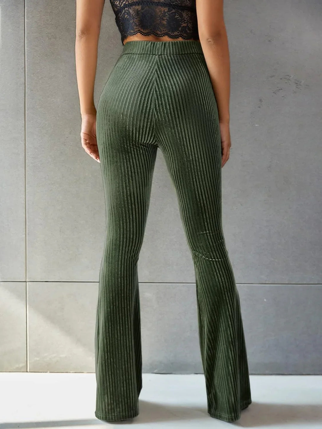Vrouw loopt in een bruine corduroy flared broek met hoge taille, comfortabel en modieus.