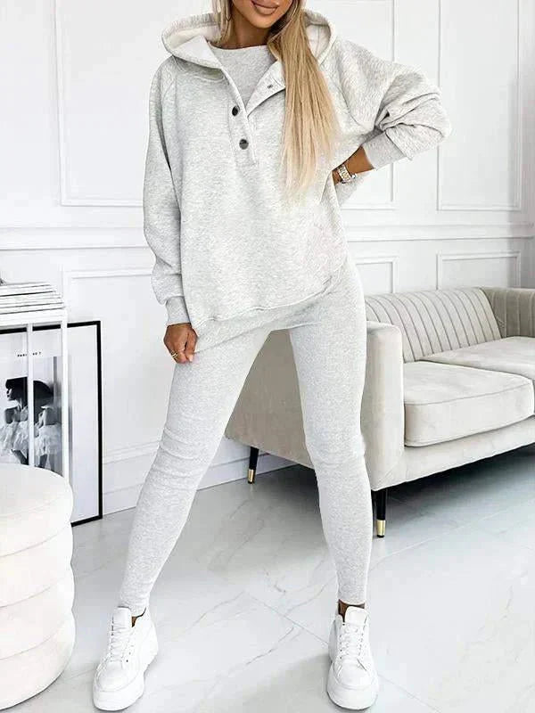 Vrouwelijke mode: complete lounge set met capuchontrui, tanktop en strakke leggings voor binnen.