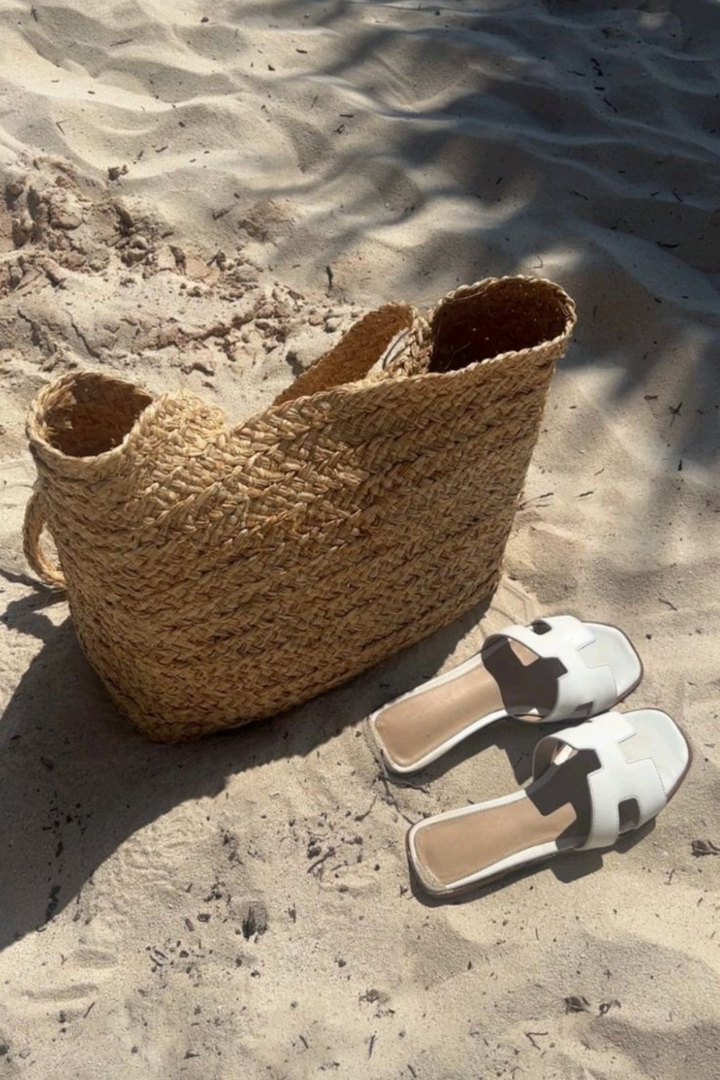 Bovenaf zicht op modieuze dames teenslippers. Elegant design en comfortabele platte zool voor zomerse outfits.