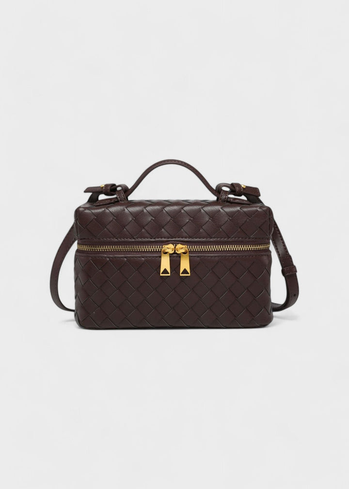 Luxe accessoire: gevlochten crossbody tas met opvallende gouden details en comfortabele band.