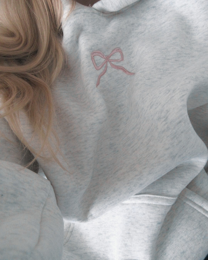 Comfortabele dames capuchontrui met lange mouwen en speelse roze strik op de borst, regular fit.