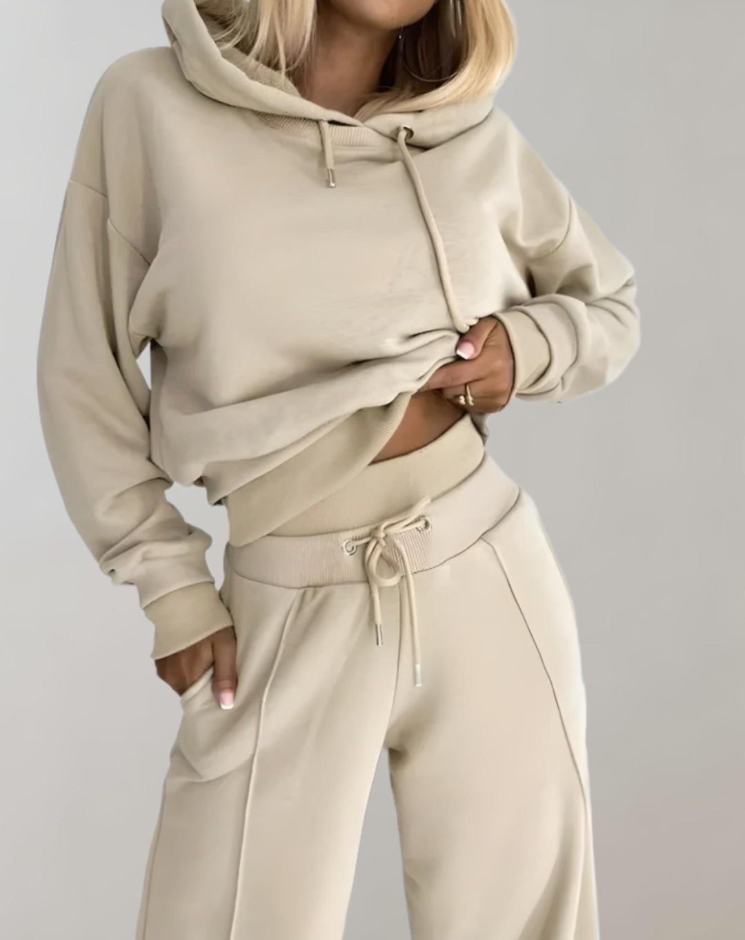 Sportief dameskleding joggingpak met moderne crop hoodie en wijde pijpen broek. Een modebewuste keuze voor comfort.