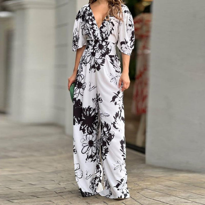 Stijlvolle feestkleding: dames jumpsuit met levendige bloemenprint, hoge taille en wijde pijpen voor een elegante uitstraling.