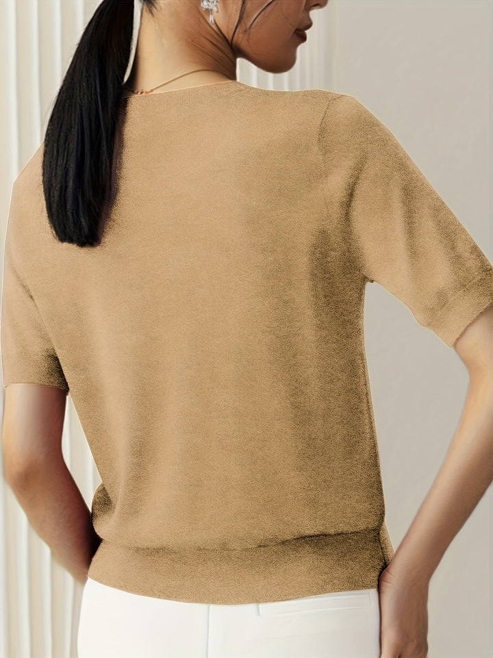 Model draagt comfortabele dames korte mouw trui, ronde hals, staand in lentezon.