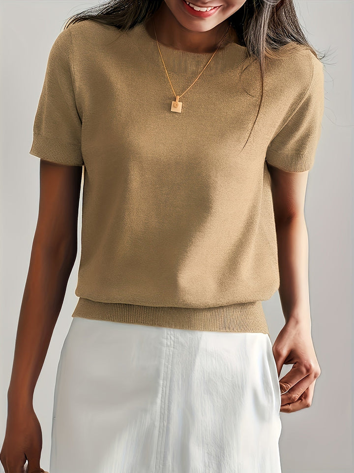 Zittend model in basic dames trui met korte mouw en ronde hals, comfortabele herfstmode.