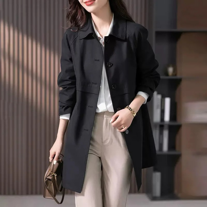 Veelzijdige zwarte korte trenchcoat, getailleerd voor dames. Geschikt als klassieke bovenkleding, zowel zakelijk als casual.