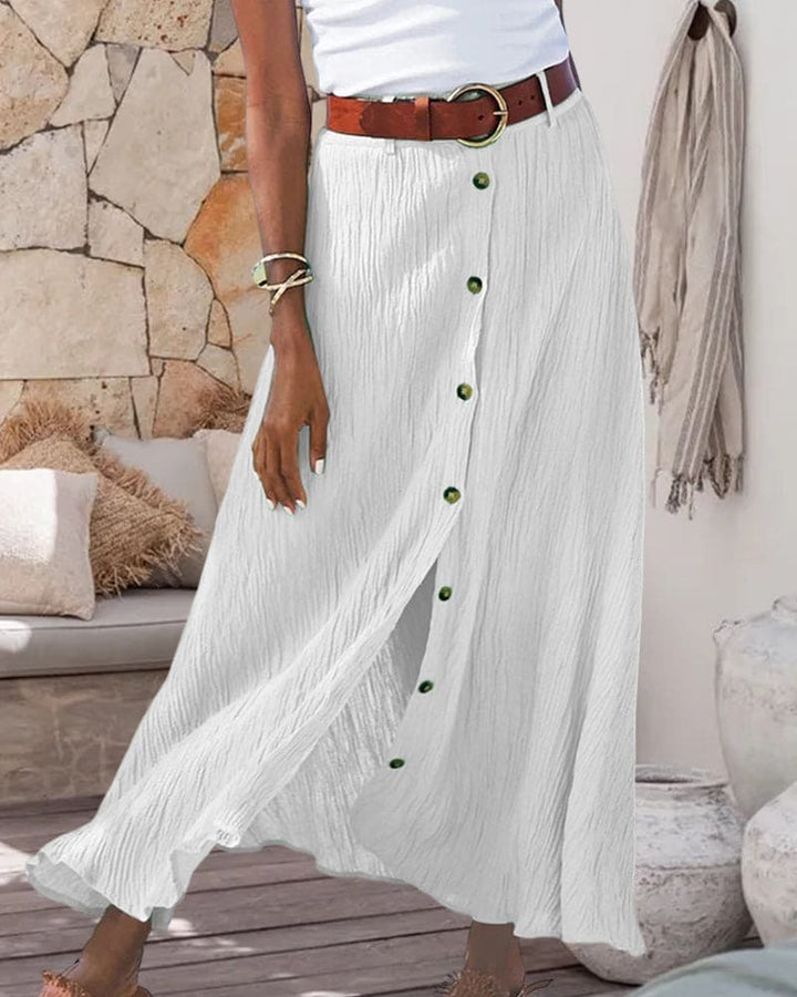 Trendy donkerblauwe lange damesrok met knoopsluiting en kreukstof, geschikt voor elegante of casual outfits.