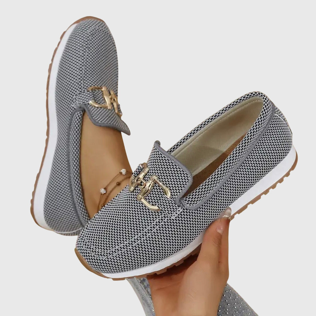 Close-up van de gouden gesp op elegante dames loafers met comfortabele plateauzool.