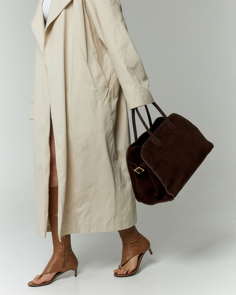 Luxe suède schoudertas voor dames, elegant design met opvallende gouden accenten. Ideaal als handtas.