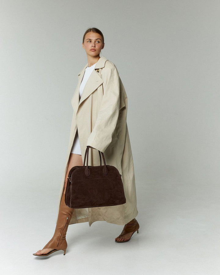 Stijlvolle dames tote tas van zacht suède, verrijkt met glimmende gouden hardware. Een chique mode accessoire.