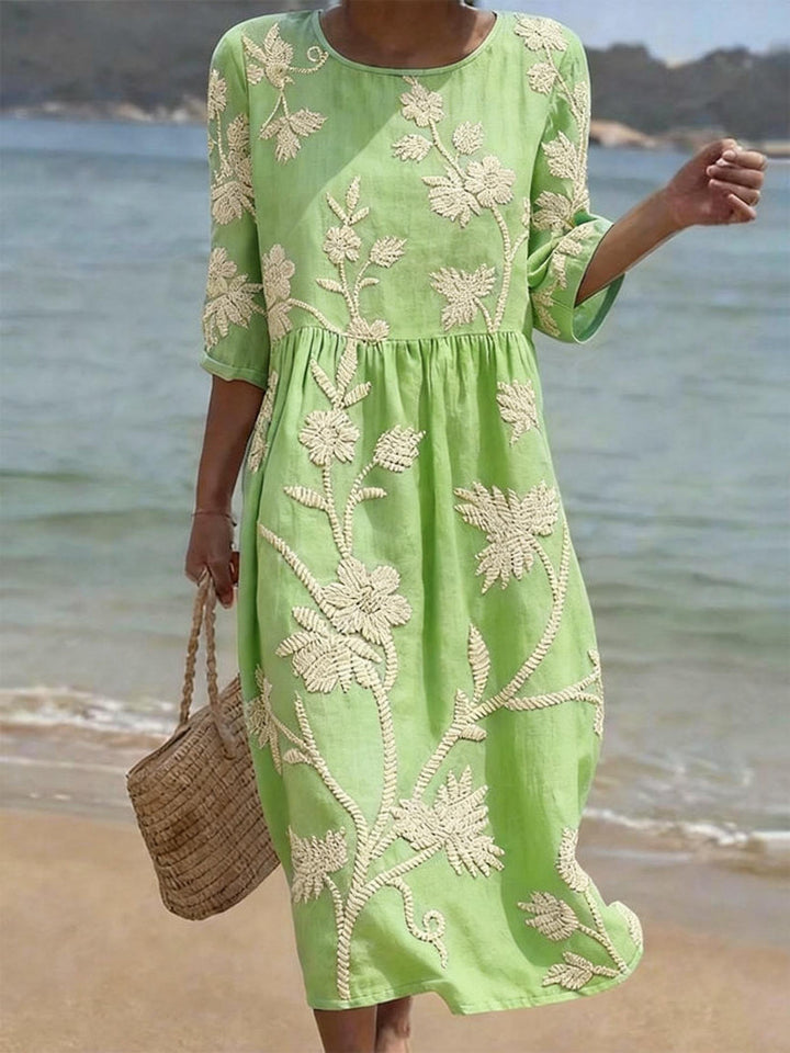 Lange dames jurk in vintage stijl met uniek bloemenborduursel, creëert een elegant en flatterend silhouet.