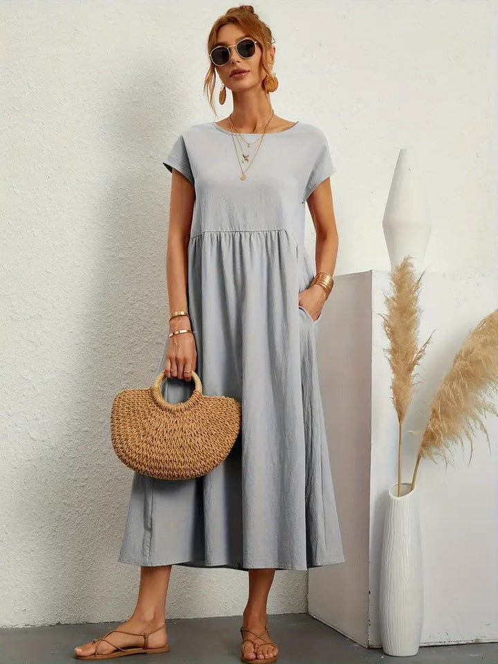 Zomerse midi jurk voor dames, korte mouwen, ronde hals en praktische zakken.