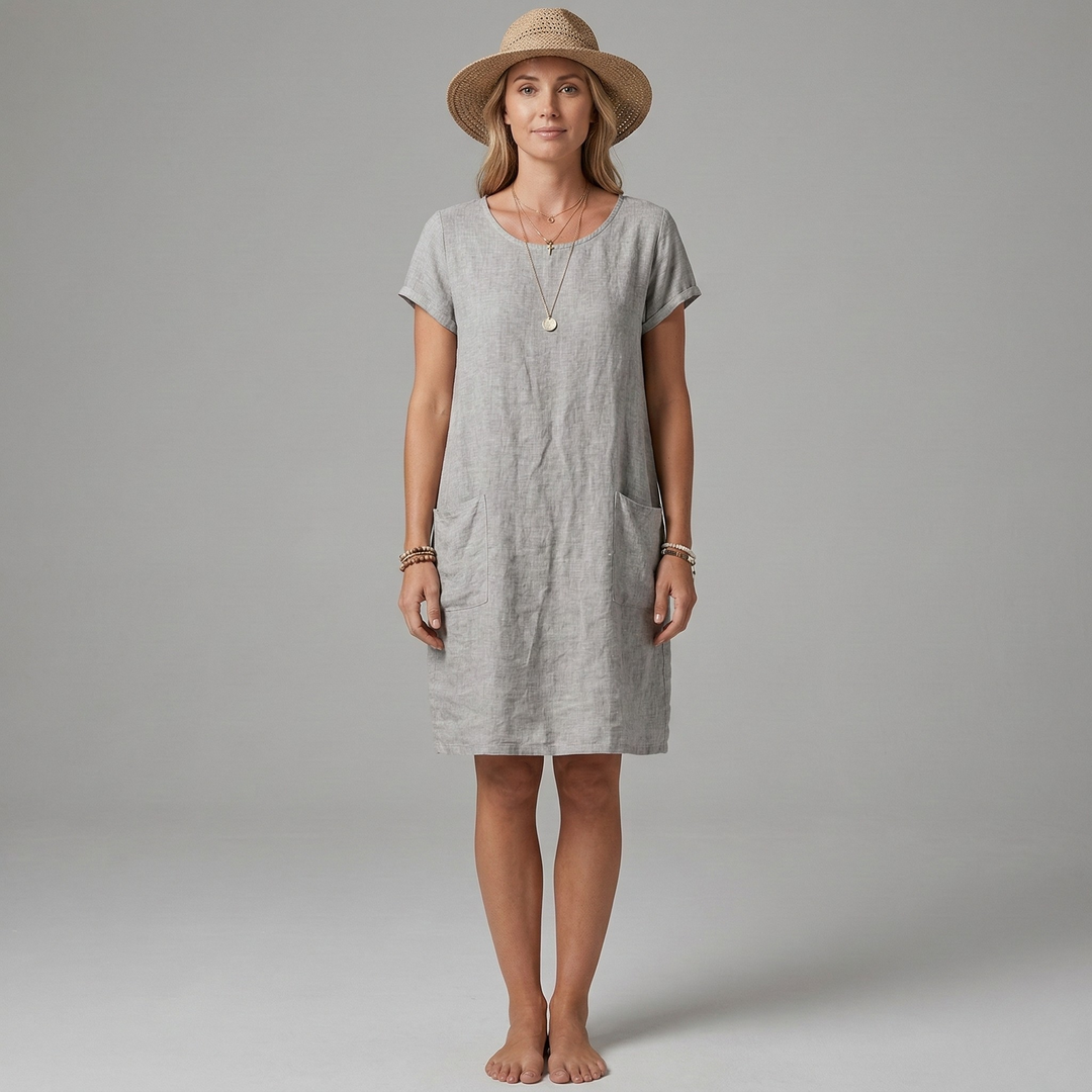 Model draagt een comfortabele dames midi jurk met korte mouwen, ronde hals en praktische zakken.