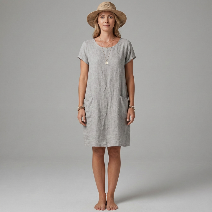 Model draagt een comfortabele dames midi jurk met korte mouwen, ronde hals en praktische zakken.
