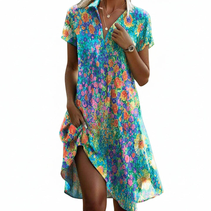Dames midi jurk met vrolijke bloemenprint, korte mouwen en elegante asymmetrische zoom. Perfect voor zomer.