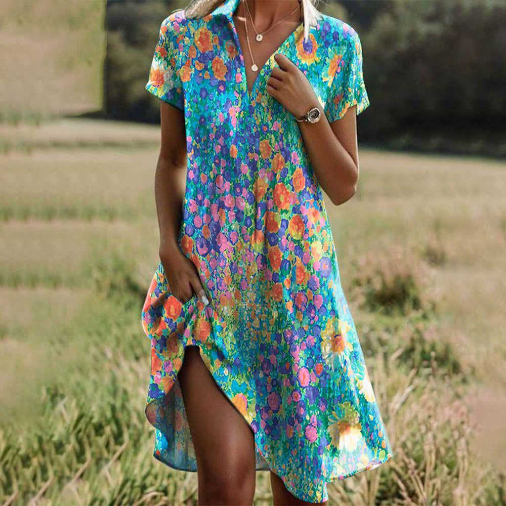 Modieuze zomerse damesjurk met bloemenprint, korte mouw en speelse asymmetrische zoom. Ideaal voor strand of vakantie.