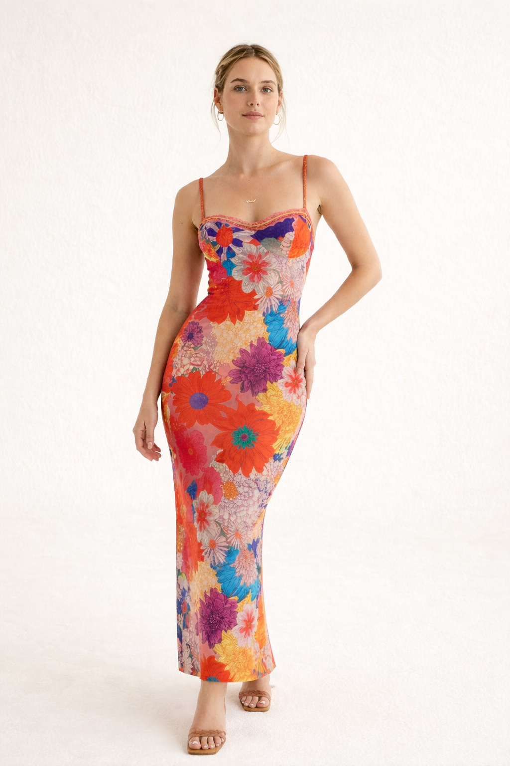 Dames oranje maxi-jurk met bloemenprint en slanke bandjes, perfect voor een zomerse dag.