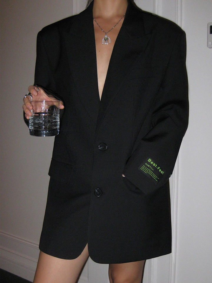 Elegante zwarte oversized blazer, gestyled met een jurk, perfect voor een chique dames outfit.