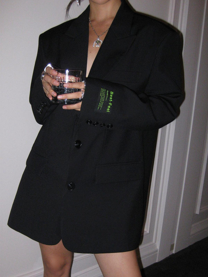 Achterkant van een grijze oversized dames blazer, toont de vloeiende, elegante pasvorm.