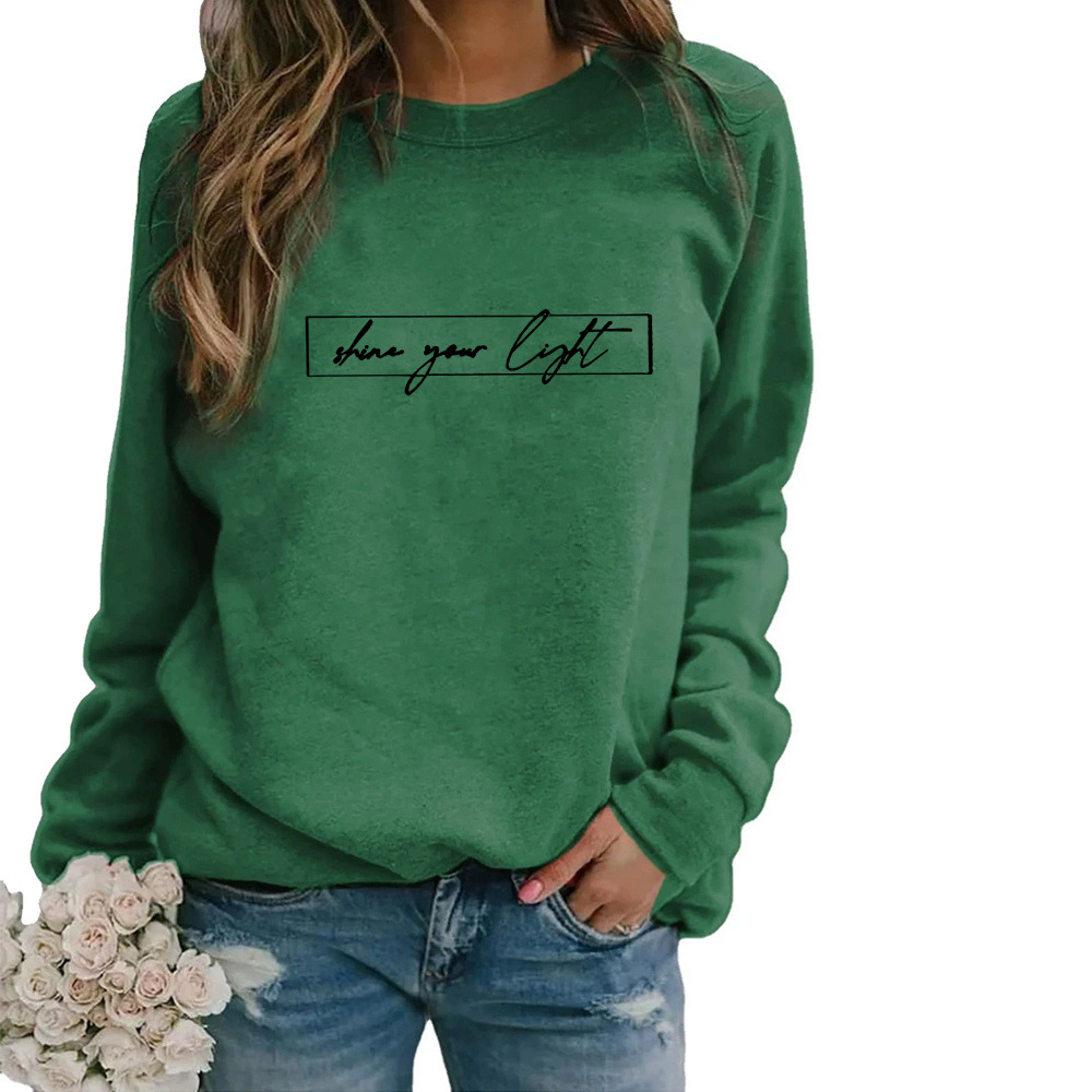 Model draagt comfortabel oversized dames sweatshirt met slogan print; toont casual, modieuze stijl.
