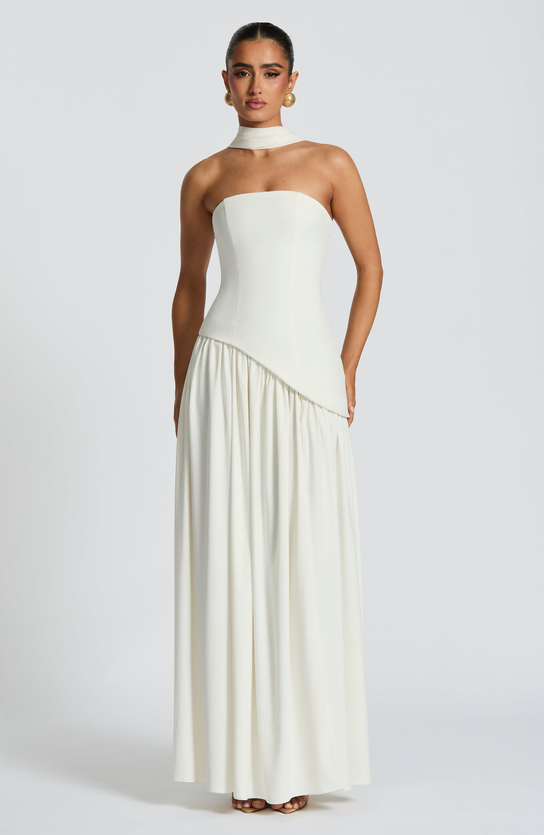 Exclusieve strapless dames maxijurk met een gevormd corset en een speelse asymmetrische taille.