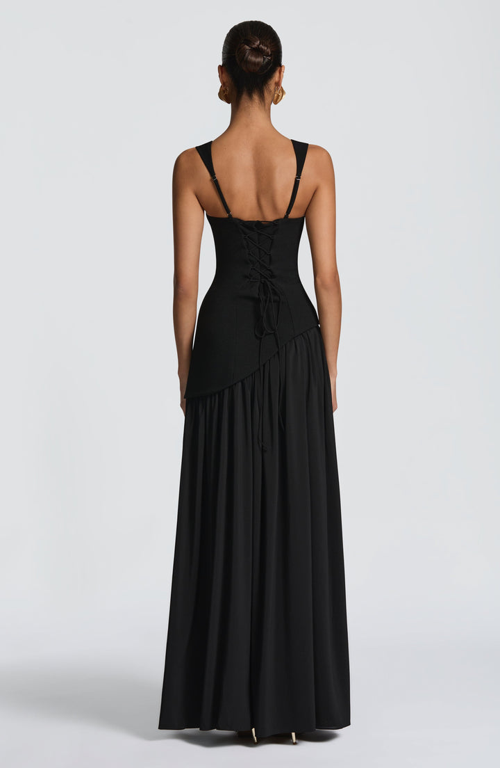 Vrouwelijke strapless maxijurk met een geraffineerd corset lijfje en een artistieke asymmetrische taille.