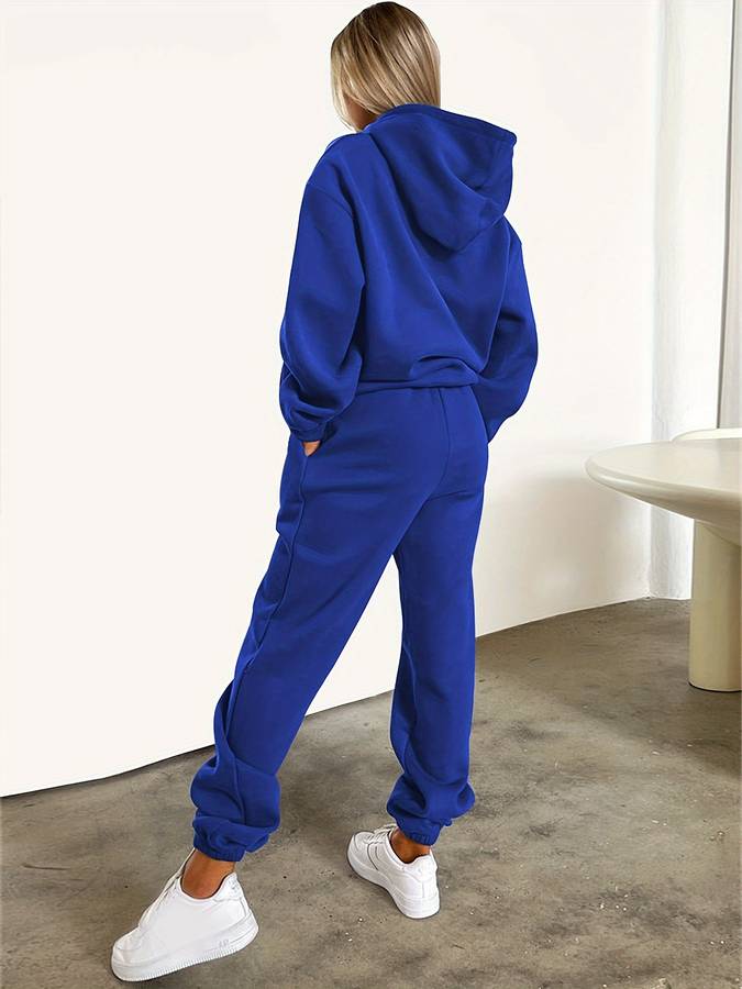 Modieus dames trainingspak met hoodie en rechte broek, perfect voor een sportieve of casual look.