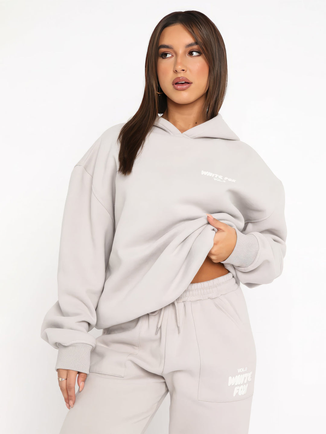 "Dames trainingspak met oversized pasvorm, wit, elastische ribboorden, trendy puffprint logo en fleecestof."