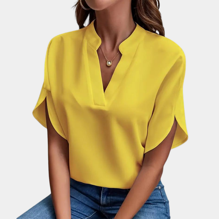 Damesmodel draagt elegante V-hals blouse met korte mouwen, luchtig en comfortabel voor de zomer.