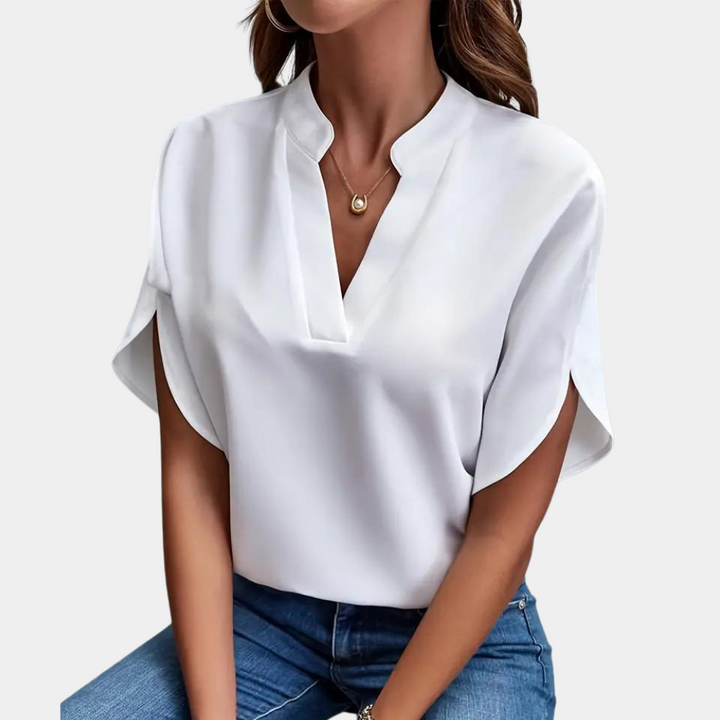 Close-up van de elegante V-hals en korte mouwen van deze modieuze dames zomerblouse. Flatterende pasvorm.