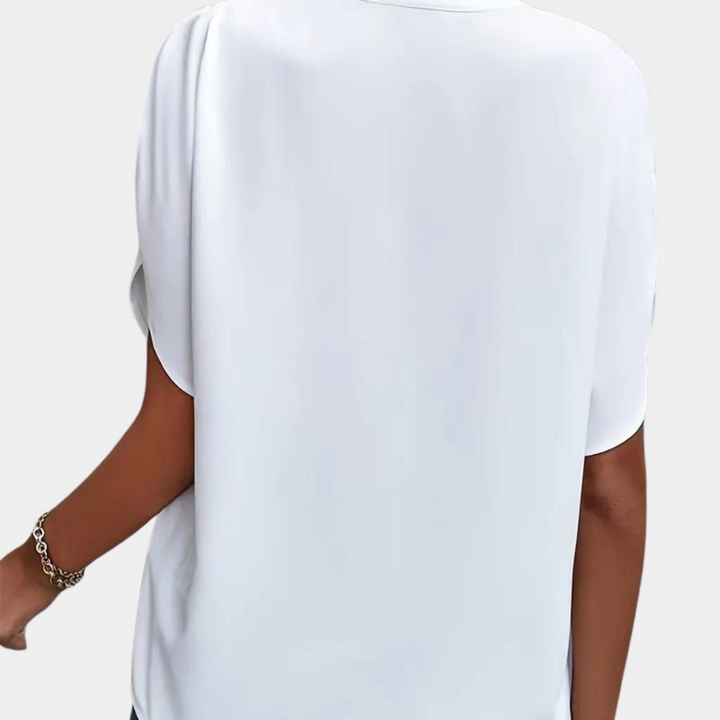 Detail van de luchtige stof en pasvorm van de dames V-hals blouse met korte mouwen. Perfecte zomerkleding.