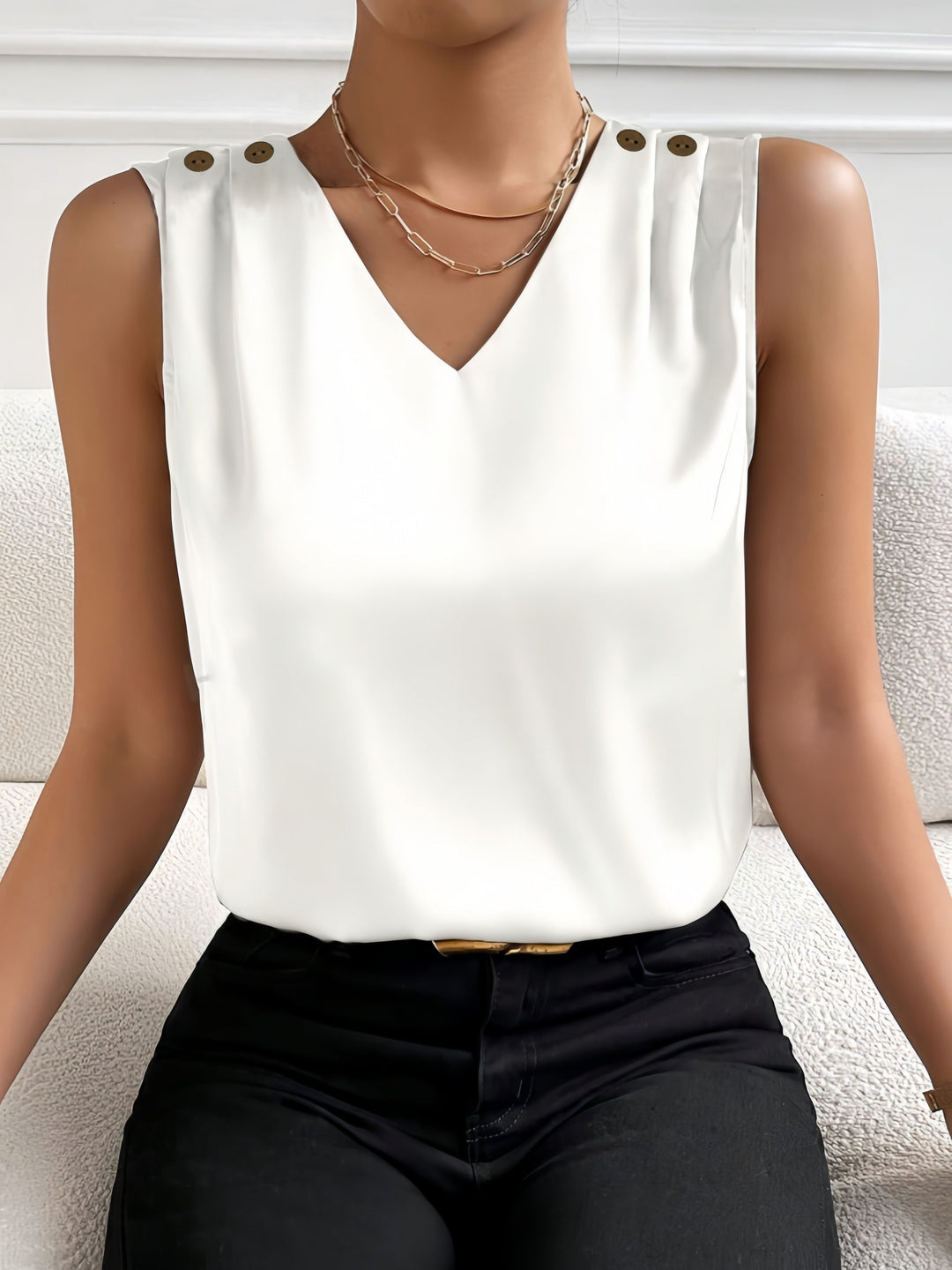 Dames V-hals mouwloze top met stijlvolle knoopdetails. Comfortabel en modieus voor de zomer.
