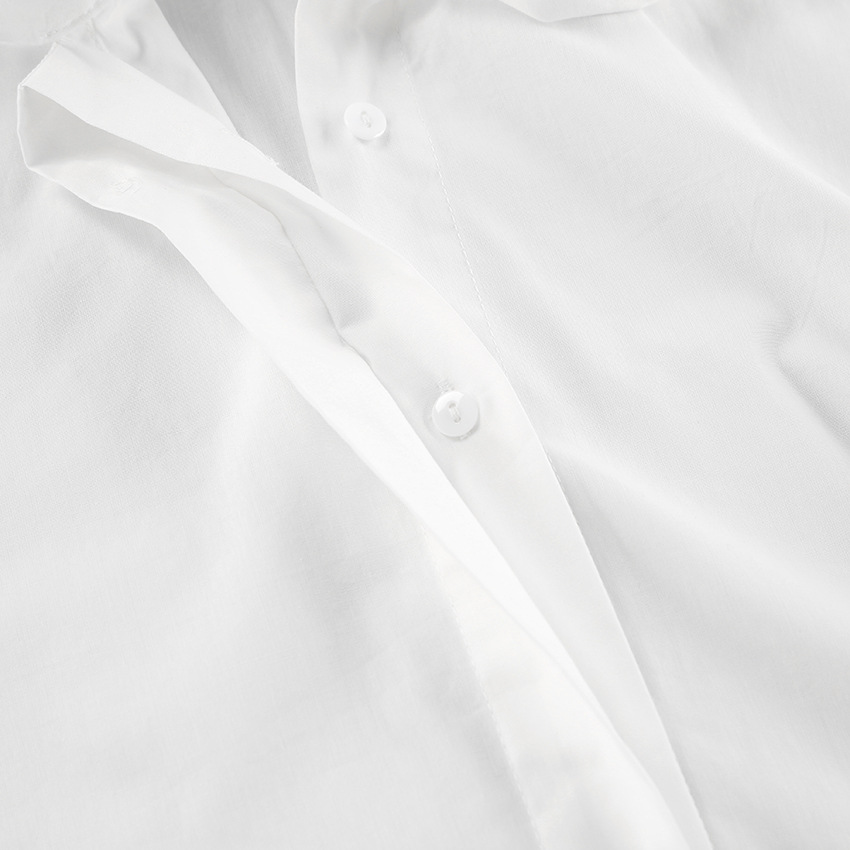 Close-up van de kraag en strik van het elegante witte dames overhemd, een klassieke strikblouse.
